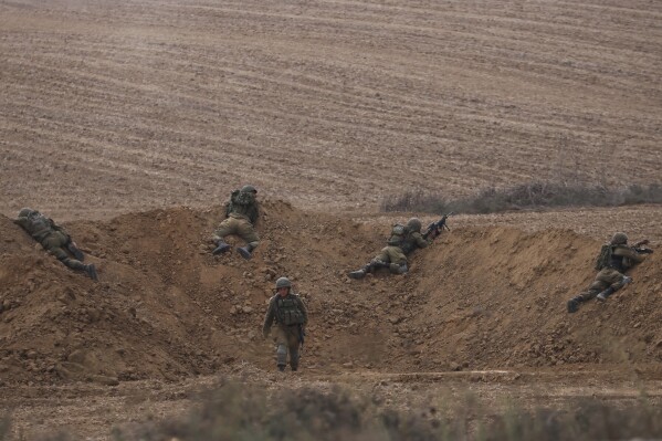 FILE - Israeli soldiers take position near the Israeli Gaza border, southern Israel, Monday, Oct. 9, 2023. (AP Photo/Oren Ziv, File)